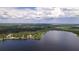 Scenic aerial view of a waterfront property on a serene lake surrounded by lush greenery at 2292 Se 170Th Avenue Rd, Silver Springs, FL 34488