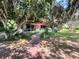 Lush backyard featuring a patio and walkway that leads to the house, offering serene views at 2292 Se 170Th Avenue Rd, Silver Springs, FL 34488