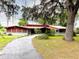 Charming home exterior featuring a long driveway, mature trees, and well-kept landscaping at 2292 Se 170Th Avenue Rd, Silver Springs, FL 34488