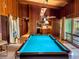 Spacious game room featuring a pool table, wood paneling, and an open view to the kitchen area at 2292 Se 170Th Avenue Rd, Silver Springs, FL 34488