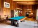 Inviting game room with a pool table, wood paneled walls, and a view into the adjacent kitchen at 2292 Se 170Th Avenue Rd, Silver Springs, FL 34488