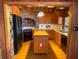 Well-lit kitchen featuring wood cabinets, a center island, brick accent wall, and modern appliances at 2292 Se 170Th Avenue Rd, Silver Springs, FL 34488