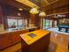 The kitchen with an island cooktop, a double sink, orange cabinets, and views of the pool table at 2292 Se 170Th Avenue Rd, Silver Springs, FL 34488