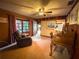 Cozy living room featuring a ceiling fan, hardwood walls, and large window offering ample natural light at 2292 Se 170Th Avenue Rd, Silver Springs, FL 34488