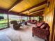 Bright living room boasts beamed ceilings, wood paneled walls, and lake views at 2292 Se 170Th Avenue Rd, Silver Springs, FL 34488