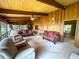 Spacious living room features wood paneled walls, beamed ceilings, and comfortable seating, great for entertaining at 2292 Se 170Th Avenue Rd, Silver Springs, FL 34488