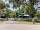 Gated property entrance with mature trees, a green outbuilding, and lush landscaping, plus a mailbox at 2292 Se 170Th Avenue Rd, Silver Springs, FL 34488