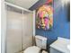 Stylish bathroom with a glass-enclosed shower, contemporary toilet, sink, and funky wall art at 97 Parson Dr, Winter Haven, FL 33884