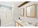 Bathroom featuring double sinks, framed mirrors, and a shower-tub combo with safety bars at 97 Parson Dr, Winter Haven, FL 33884