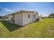 Exterior rear showing the lawn, covered patio, vinyl siding, awning and AC unit at 97 Parson Dr, Winter Haven, FL 33884