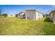 Rear exterior view showing the lawn, well maintained siding, AC unit, and nearby home at 97 Parson Dr, Winter Haven, FL 33884