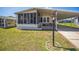 Charming home featuring a screened porch, covered parking, a bench, and well-maintained landscaping at 97 Parson Dr, Winter Haven, FL 33884
