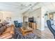 Cozy living area with a sofa, accent chair, mounted television, and a ceiling fan at 97 Parson Dr, Winter Haven, FL 33884