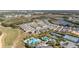 Aerial view featuring community pools, tennis courts, and a pond surrounded by houses at 1890 Flora Pass Pl, Kissimmee, FL 34747