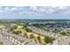 Elevated aerial view of a neighborhood adjacent to a green golf course, demonstrating an environment with mature trees at 1890 Flora Pass Pl, Kissimmee, FL 34747