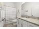 Bright bathroom with granite countertop, white cabinetry, and shower with patterned curtain at 1890 Flora Pass Pl, Kissimmee, FL 34747