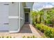 Inviting covered entryway featuring brick pavers surrounded by verdant, tropical landscaping at 1890 Flora Pass Pl, Kissimmee, FL 34747