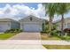 Charming single-Gathering home featuring a well-manicured lawn and a two-car garage with brick paver driveway at 1890 Flora Pass Pl, Kissimmee, FL 34747