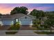 Charming home featuring a two-car garage, beautiful landscaping, and a brick driveway at 1890 Flora Pass Pl, Kissimmee, FL 34747