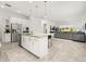 Open-concept kitchen featuring stainless steel appliances, granite countertops, and an island with bar seating at 1890 Flora Pass Pl, Kissimmee, FL 34747