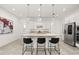 Modern kitchen boasts stainless steel appliances, a granite island, and sleek white cabinets at 1890 Flora Pass Pl, Kissimmee, FL 34747