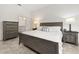 A bright main bedroom with wood furniture and convenient access to the bathroom at 1890 Flora Pass Pl, Kissimmee, FL 34747