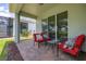 Covered outdoor patio with comfortable chairs and a table, perfect for enjoying the backyard at 1890 Flora Pass Pl, Kissimmee, FL 34747