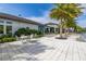 Luxury pool area with lounge chairs, tables, umbrellas, lush landscaping, and a clubhouse at 1890 Flora Pass Pl, Kissimmee, FL 34747