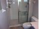 Bathroom featuring a tiled shower with a glass door next to a toilet with gray walls at 8225 Sw 108Th Street Rd, Ocala, FL 34481