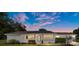 Inviting single-story home with solar panels, front porch, and professionally landscaped yard at twilight at 8225 Sw 108Th Street Rd, Ocala, FL 34481