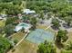 Aerial view of the community clubhouse, pool and tennis courts surrounded by lush green trees at 9700 Sw 196 Circle, Dunnellon, FL 34432