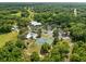 Aerial view of a community center with a pool and tennis court surrounded by trees at 9700 Sw 196 Circle, Dunnellon, FL 34432