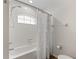 Bright bathroom featuring a shower-tub combo with a white tile surround and arched window at 9700 Sw 196 Circle, Dunnellon, FL 34432