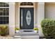 Close-up of front door with glass inserts and decorative plants on the front porch at 9700 Sw 196 Circle, Dunnellon, FL 34432