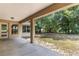 Covered patio overlooking a spacious backyard with lush greenery and mature trees at 9700 Sw 196 Circle, Dunnellon, FL 34432