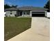 Charming single-story home with a well-manicured lawn and a spacious driveway leading to an attached garage at 15094 Sw 43Rd Avenue Rd, Ocala, FL 34473