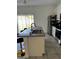 Bright kitchen with stainless steel appliances, a granite countertop island, and neutral-toned tile flooring at 15094 Sw 43Rd Avenue Rd, Ocala, FL 34473