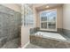Bright bathroom features a soaking tub, walk-in shower with glass brick, and private toilet area at 629 Orange Valley Ln, Lakeland, FL 33813