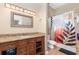 Bathroom with granite counters, wood cabinets, and shower with modern curtain at 629 Orange Valley Ln, Lakeland, FL 33813
