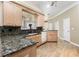 Well-lit kitchen featuring granite countertops, light wood cabinets, and modern appliances at 629 Orange Valley Ln, Lakeland, FL 33813