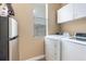 Laundry area with a washer, dryer, refrigerator, window and white cabinets at 629 Orange Valley Ln, Lakeland, FL 33813