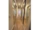 Long hallway with mirrored closet doors and wood-look tile flooring leading to other rooms at 12064 Navale Ln, Orlando, FL 32827
