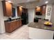 Functional kitchen featuring warm wood cabinets, black appliances, and granite countertops at 12064 Navale Ln, Orlando, FL 32827