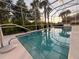 Inviting screened-in pool with serene views of the surrounding lush landscaping and setting sun at 12064 Navale Ln, Orlando, FL 32827