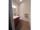 Well-lit powder room with wood-look tile floors, vanity with sink and a decorative hand towel at 12064 Navale Ln, Orlando, FL 32827
