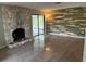 Bright living room boasts a stone fireplace, decorative wood wall, and sliding glass doors to the patio at 2123 Woodburn S Loop, Lakeland, FL 33813