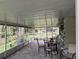 Enclosed patio features brick flooring, table, chairs, and view of the landscaped backyard at 2123 Woodburn S Loop, Lakeland, FL 33813