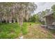 Large backyard featuring a shed and mature tree, offering a secluded and private outdoor space at 303 Clayton Rd, Auburndale, FL 33823