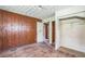 This bedroom has original wood paneling, a textured ceiling, and an original closet at 303 Clayton Rd, Auburndale, FL 33823