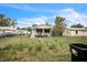 Simple home with a chain link fence and grassy front yard under a sunny sky at 303 Clayton Rd, Auburndale, FL 33823